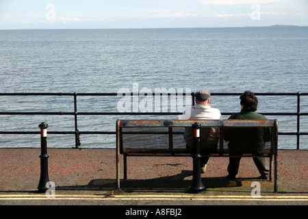 Couple d'âge moyen à la mer sur la promenade de front de Whitehead, comté d'Antrim, en Irlande du Nord Banque D'Images