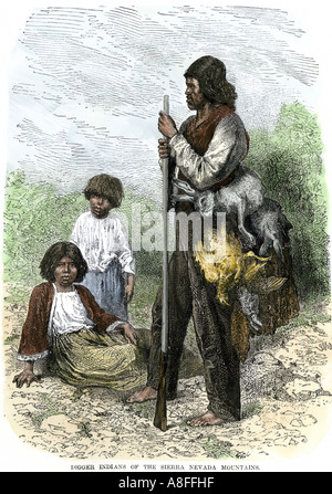 Digger Indiens revenant d'une chasse transportant des lapins et des oiseaux dans les montagnes de la Sierra Nevada des années 1800. À la main, gravure sur bois Banque D'Images