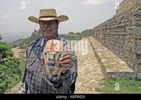 Un vendeur de souvenirs et objets d'écran copies un masque devant un temple au site archéologique de Monte Alban, Oaxaca, Mexique Banque D'Images