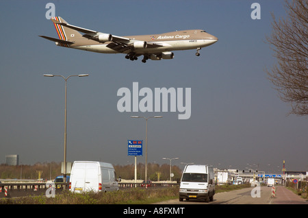 Un Boeing 747 jumbo jet en courte finale passe bas au-dessus du trafic à l'aéroport de Schipol Amsterdam Banque D'Images