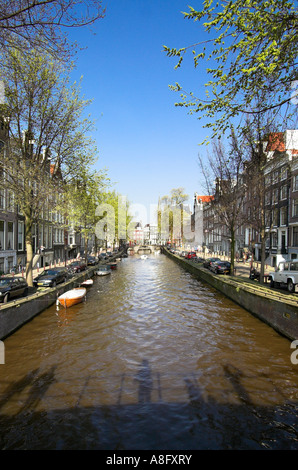 Vue le long d'un canal à Amsterdam avec l'ombre du pont et les piétons exprimés sur l'eau Banque D'Images