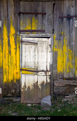 Hangar délabré avec de la peinture jaune et porte, Morzine, France. Banque D'Images