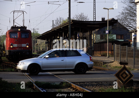 Voiture roulant à travers un passage à niveau devant un train, Leichlingen, Rhénanie du Nord-Westphalie, Allemagne. Banque D'Images