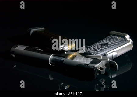 Pistolet semi-automatique avec chargeur plein studio nature morte noir sur fond réfléchissant Banque D'Images