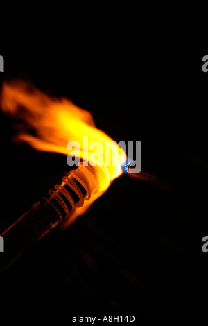 Le verre fondu sur la tige qui est chauffé à la flamme du gaz avant de souffler la flamme à contraste élevé Banque D'Images