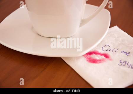 Tasse de café et marque de rouge à lèvres message écrit sur le tissu close up Banque D'Images