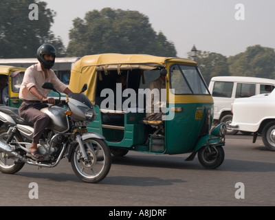 La circulation sur route très fréquentée avec vert et jaune auto rickshaw alimentée au gaz naturel comprimé GNC. L'Uttar Pradesh Inde New Delhi Banque D'Images