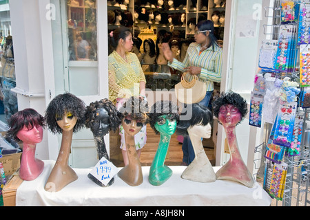 Deux femmes discutent dans la boutique perruque en marché de Brixton, Londres Banque D'Images