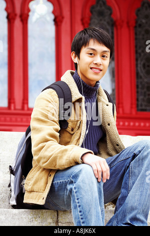 Portrait of a young man sitting on steps and smiling Banque D'Images