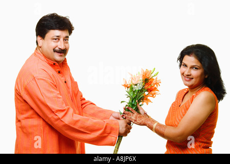 Portrait d'un homme mûr donnant un bouquet de fleurs à une Mid adult woman Banque D'Images