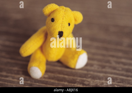 Petit ours en peluche assis sur un siège en bois ou d'une table Banque D'Images