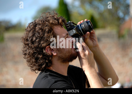 Vingt-deux ans, jeune homme à prendre des photos avec l'appareil photo Nikon. Banque D'Images