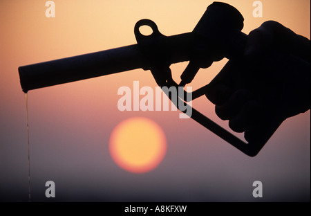 Une pompe à essence et le coucher du soleil Banque D'Images