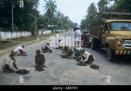 Le travail forcé au Myanmar - appuyez les travailleurs en goudron chaud-de-poule dans la route Banque D'Images