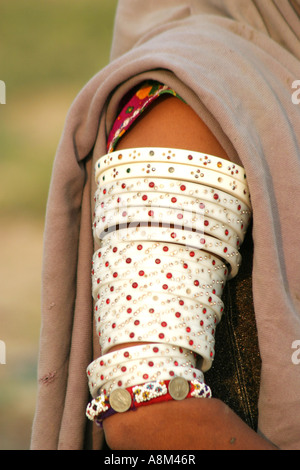 Un bras womans tribal Mir couverts de bracelets en plastique incrustés de pierres de couleur.A l'origine de l'ivoire a toujours été utilisée. Banque D'Images