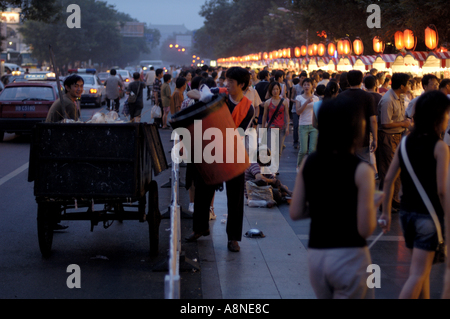 La collecte des déchets les hommes au marché de nuit de Wangfujing, Beijing, Chine. Banque D'Images