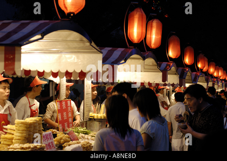 Les gens achètent des aliments auprès de fournisseurs au marché de nuit de Wangfujing, Beijing, Chine. Banque D'Images