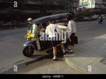 L'école thaïlandaise enfants portant l'uniforme scolaire passe à la maison de l'école, les cartables, transportant la négociation de bordure de tuk-tuk à Bangkok, Thaïlande Banque D'Images