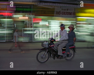 Couple sur une moto dans les rues de Hanoi, Vietnam Banque D'Images