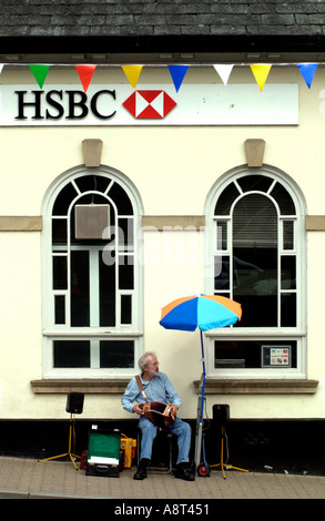 Musicien ambulant en dehors de la banque HSBC à Hay-on-Wye Powys Pays de Galles UK Banque D'Images