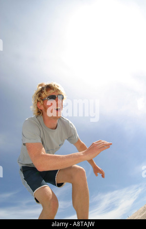 Jeune homme blond à jouer au volleyball de plage Banque D'Images