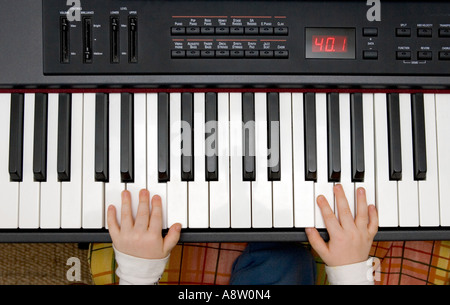 Les jeunes garçons mains jouant de la musique sur un piano ou clavier électronique Banque D'Images