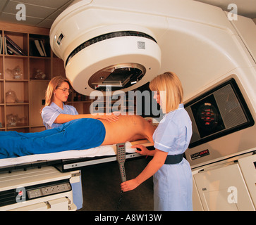 Jeune femme radiothérapeute positioning accélérateur linéaire de radiothérapie machine avec senior male patient. Banque D'Images