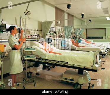 Jeune femme infirmière de l'hôpital avec des patients en soins intensifs. Banque D'Images