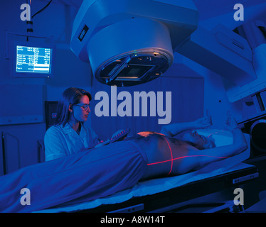 Jeune femme radiothérapeute positioning accélérateur linéaire de radiothérapie machine avec senior male patient. Banque D'Images