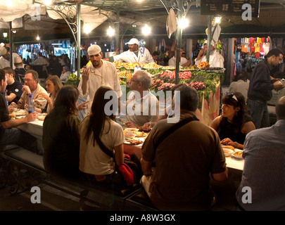 Manger en place Jemaa El Fna de Marrakech Maroc Banque D'Images