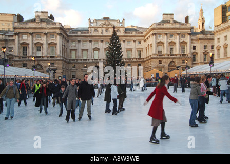 Cour historique de Somerset House avec décorations d'arbres de Noël et personnes appréciant l'arène de patinage sur glace extérieure au Strand London Angleterre Banque D'Images