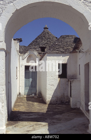 Trulli résidentiel traditionnel vu à travers une arche dans le vieux quartier d'Alberobello, Puglia, Italie, par une journée ensoleillée Banque D'Images