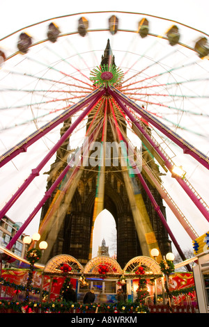 Grande roue de Noël à Édimbourg en contraste le Scott Monument Banque D'Images