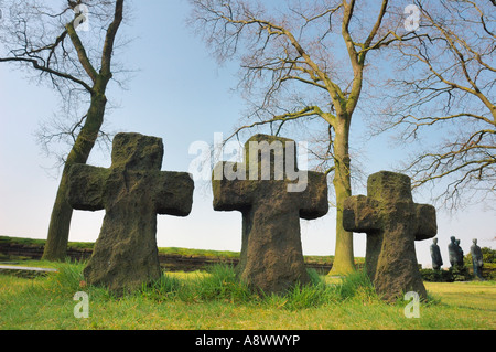 Les tombes de soldats allemands 3 dans le cimetière de guerre de Langemark, Belgique. Des statues de soldats dans l'arrière-plan. Banque D'Images