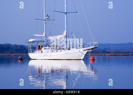 Yacht blanc et bouées rouges sur une eau bleue. Le port de Poole. Le Dorset. UK (Yacht nom supprimé) Banque D'Images