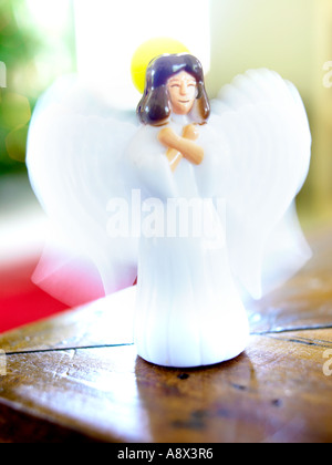 Les ailes battantes ange en plastique en face de l'arbre de Noël sur la table debout Banque D'Images