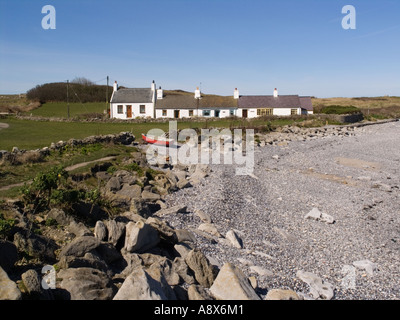 Plage de galets avec rangée de cottages blancs à côté de l''Anglesey sentier côtier. Llangefni Anglesey au nord du Pays de Galles UK Banque D'Images
