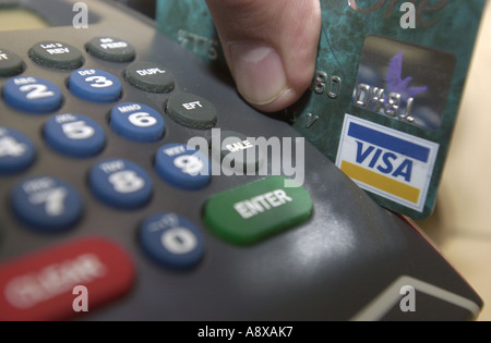 Carte de crédit glissée dans une machine par un homme UK Banque D'Images