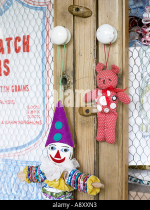 Chiffon vieux clown et ours en peluche avec des boutons accroché sur une armoire avec portes fil de poulet Banque D'Images