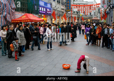 Chinese Girl Street Performer et mendiant Shang Xia Jiu Square Shopping mall piétonnier très occupé à Guangzhou Chine Banque D'Images