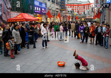 Chinese Girl Street Performer et mendiant Shang Xia Jiu Square Shopping mall piétonnier très occupé à Guangzhou Chine Banque D'Images