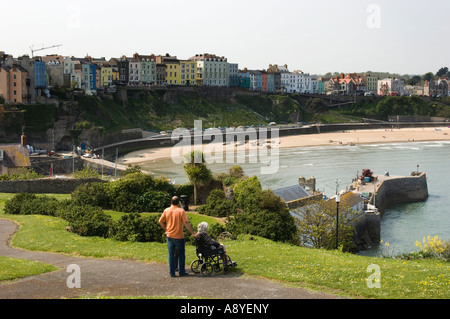 Tenby, Pembrokeshire wales ouest vu de la colline du château à la plage du nord, vers l'après-midi d'été, woman in wheelchair  + helper Banque D'Images