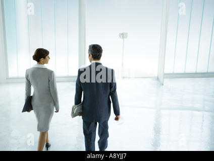 Partenaires d'affaires, hommes et femmes à marcher en direction de la porte de hall Banque D'Images