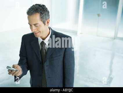 Businessman checking des messages texte sur téléphone cellulaire Banque D'Images