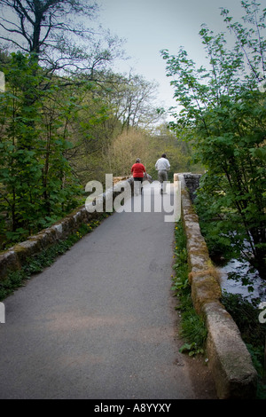 Mature couple walking sur Fingle Bridge sur la rivière Teign près de Dartmoor en Angleterre Devon Drewsteignton Banque D'Images