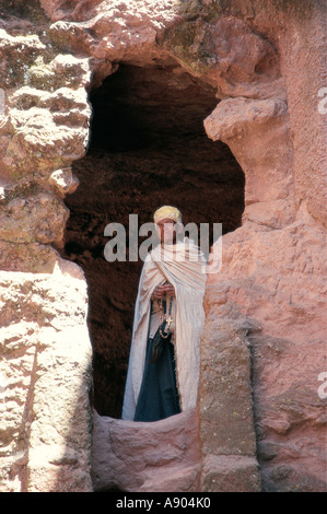 Prêtre à l'entrée d'une église de taille de roche de l'Afrique de l'Est Ethiopie Lalibela Banque D'Images