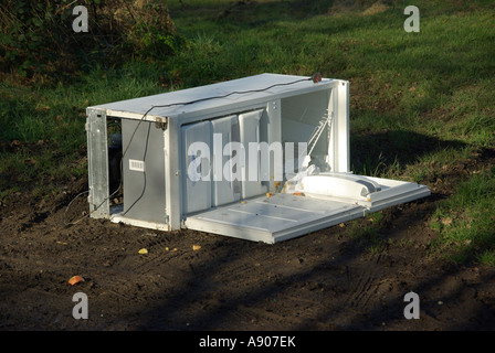 Les décharges sauvages de grands biens blanc réfrigérateur congélateur appareil électrique à côté de la route faisant l'objet d'un chemin de campagne en campagne agricole Essex England UK Banque D'Images