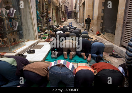 Les fidèles à genoux pour la prière scène de rue Le Caire islamique Le Caire Egypte Afrique du Nord Banque D'Images