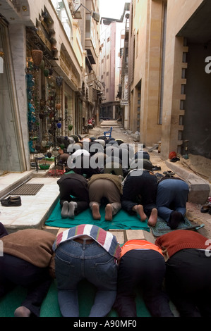 Les fidèles à genoux pour la prière scène de rue Le Caire islamique Le Caire Egypte Afrique du Nord Banque D'Images