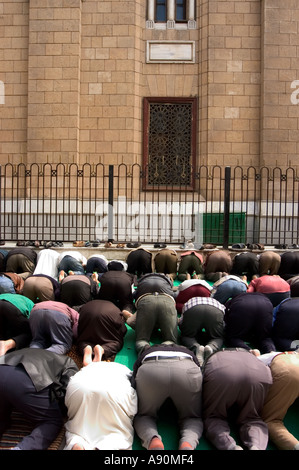 Les fidèles à genoux pour la prière scène de rue Le Caire islamique Le Caire Egypte Afrique du Nord Banque D'Images